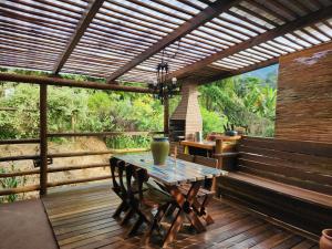 a patio with a table and chairs on a deck at Casa Limoeiro in Petrópolis