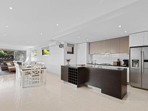 an open kitchen and living room with a table and chairs at Time Out on Flinders in Indented Head