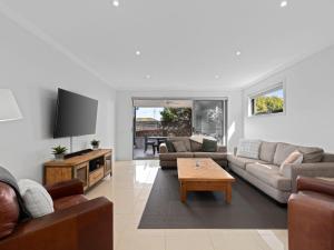 a living room with two couches and a table at Time Out on Flinders in Indented Head