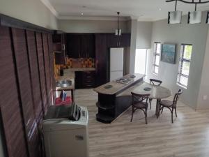a kitchen with a table and chairs and a kitchen with a counter at UVongo Welcome House in Margate
