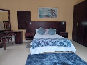 a bedroom with a large bed with blue pillows at UVongo Welcome House in Margate