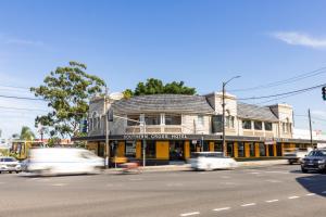 a building on the corner of a street with cars at Southern Cross Hotel in Sydney