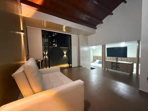 a living room with a white couch and a television at LoftBrothers39 in Bucaramanga