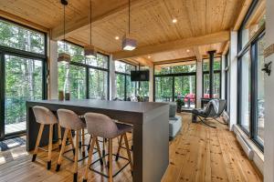 Eine Küche und ein Wohnzimmer mit einer großen Bar mit Hockern in der Unterkunft Chic & Bois in La Conception