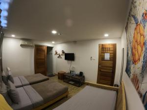 a hotel room with two beds and a tv at Silver Reef Dive Resort in Dauin