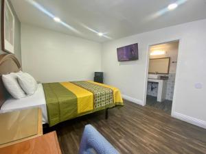 a hotel room with a bed and a television at Long Beach Motel in Long Beach
