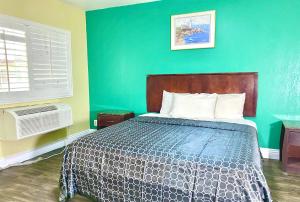 a bedroom with a bed and a green wall at Long Beach Motel in Long Beach