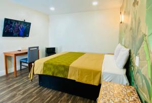 a room with a bed and a desk and a table at Long Beach Motel in Long Beach +3 photos