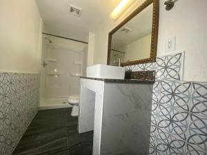 a bathroom with a sink and a mirror and a toilet at Long Beach Motel in Long Beach