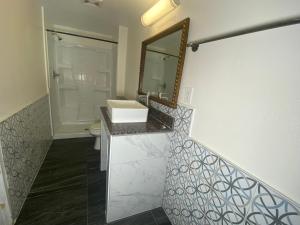 a bathroom with a sink and a mirror at Long Beach Motel in Long Beach