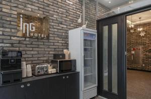 a kitchen with a refrigerator and a brick wall at Daejeon Dunsan ING Hotel in Daejeon