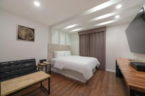 a hotel room with a white bed and a bench at Daejeon Dunsan ING Hotel in Daejeon +13 photos