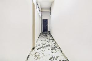 an empty corridor with marble floors and a black door at Collection O Verena in Indore