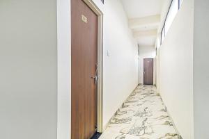 an empty corridor with a tile floor and a door at Collection O Verena in Indore