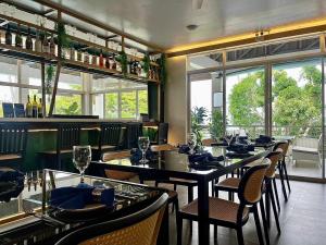 a dining room with tables and chairs and windows at Silver Reef Dive Resort in Dauin