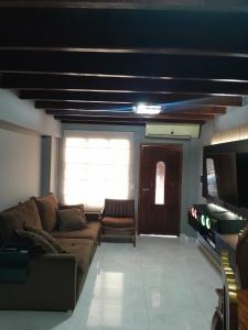 a living room with a couch and a television at Apart hotel GAVA in Encarnación +12 photos