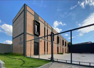 a brick building with a fence in front of it at Loft 02 - Alvares machado in Álvares Machado