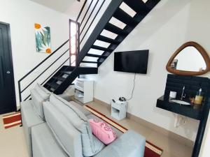 a living room with a couch and a staircase at Loft 02 - Alvares machado in Álvares Machado