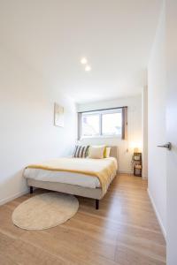 a white bedroom with a bed and a window at jeje asahikawa in Asahikawa