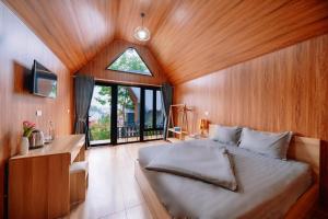 a bedroom with a bed and a desk and a window at Cat Ba Spring Homestay in Cat Ba