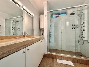a bathroom with a glass shower and a sink at Hotel Tempo Rent in Santiago +91 photos