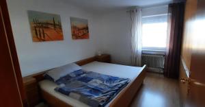a small bedroom with a bed with two pictures on the wall at Monteurwohnung in Patersdorf