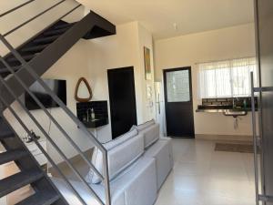 a living room with a staircase and a stair case at Loft 02 - Alvares machado in Álvares Machado +29 photos