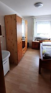 a bedroom with a bed and a wooden closet at Monteurwohnung in Patersdorf