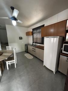 a kitchen with a white refrigerator and a table at Casa na Natureza Próx Pomerode e Timbó in Rio dos Cedros