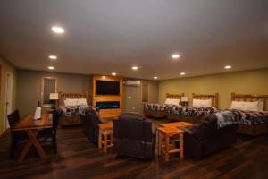 a room with three beds and a living room with couches at Nisqually Lodge in Ashford