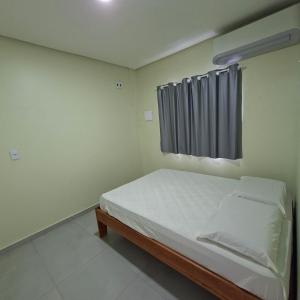 a small bedroom with a bed and a window at Apartamento Selva in Itaquatiara