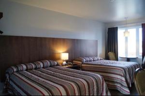 a hotel room with two beds and a window at Motel l'Églantier in Perce