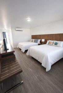 a hotel room with two beds and a desk at Motel l'Églantier in Perce