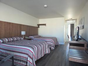 a hotel room with two beds and a television at Motel l'Églantier in Perce