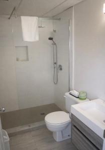 a bathroom with a shower and a toilet and a sink at Motel l'Églantier in Perce