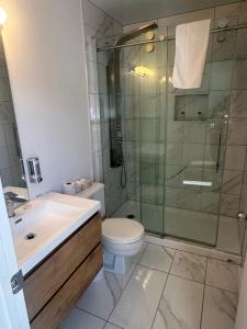 a bathroom with a shower and a toilet and a sink at Motel l'Églantier in Perce