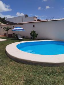 a swimming pool in front of a house with an umbrella at Villas Carlota Cancún in Cancún