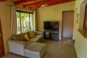a living room with a couch and a flat screen tv at Cabaña Piedra y Sol de CACHI in Cachí