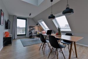 a dining room and living room with a table and chairs at Bett&Bude Boardinghouse in Westerland