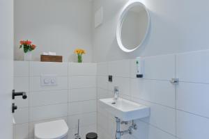 a white bathroom with a sink and a mirror at Bett&Bude Boardinghouse in Westerland +13 photos