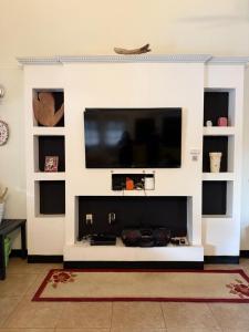 a living room with a flat screen tv on a wall at Driftwood 85 in Canaan