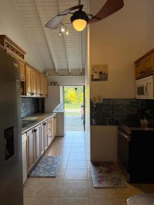 a kitchen with a ceiling fan and a kitchen with cabinets at Driftwood 85 in Canaan