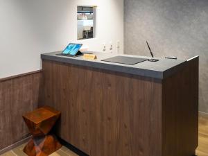 a reception desk with a laptop on top of it at TORANOMONHOLIC Hotel in Tokyo +36 photos