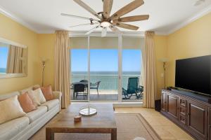 a living room with a couch and a flat screen tv at PRIVATE BEACH FRONT LUXURY CONDO, AMAZING VIEWS, INDiGO E, 5-STAR, 2 BALCONIES , PREFERRED PARTNER PRG in Pensacola