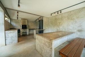 a kitchen with a counter and a wooden table at Loft no Granja Brasil Resort, Itaipava centro, Estrutura Completa in Araras Petropolis