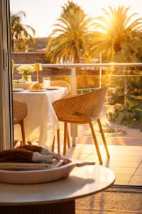 a table and chairs on a balcony with palm trees at Newly Restyled Resort 2 Bedroom Unit Oaks Pacific Blue in Salamander Bay