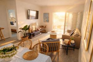 a living room with a couch and a table and chairs at Newly Restyled Resort 2 Bedroom Unit Oaks Pacific Blue in Salamander Bay