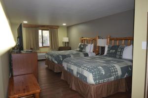 a hotel room with two beds and a television at Nisqually Lodge in Ashford