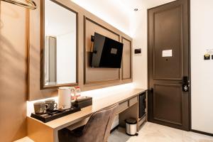 a bathroom with a desk with a tv and a mirror at Casa De Zea by AKA in Yogyakarta +50 photos