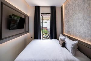 a bedroom with a white bed and a window at Casa De Zea by AKA in Yogyakarta